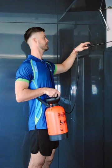 Green Clean technician holding a five-litre pressure sprayer used for pest treatments