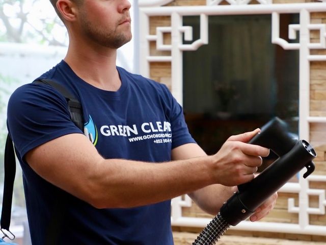 Green Clean technician holding a disinfection fogging machine in a Hong Kong home