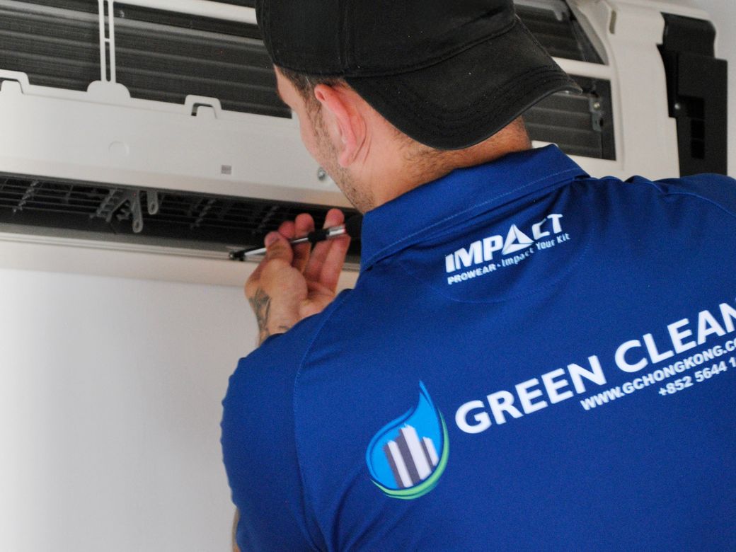 Green Clean technician servicing a wall-mounted air conditioning unit during a fit-out