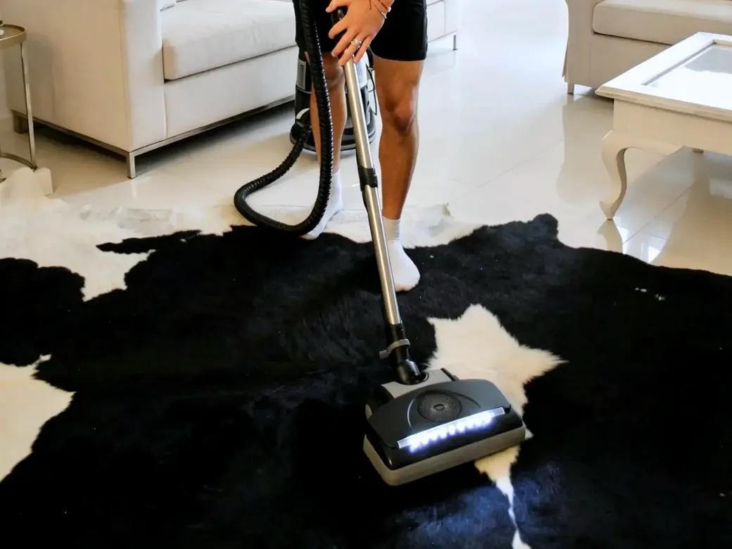 Green Clean technician vacuuming a rug in a Hong Kong living room